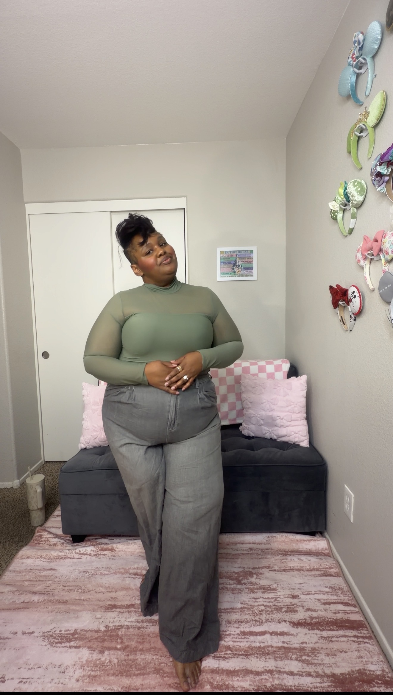 Lea wearing a sage top and gray trousers
